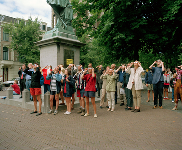 842987 Afbeelding van een groep mensen naast het standbeeld van Jan van Nassau (Domplein) te Utrecht, die met speciale ...